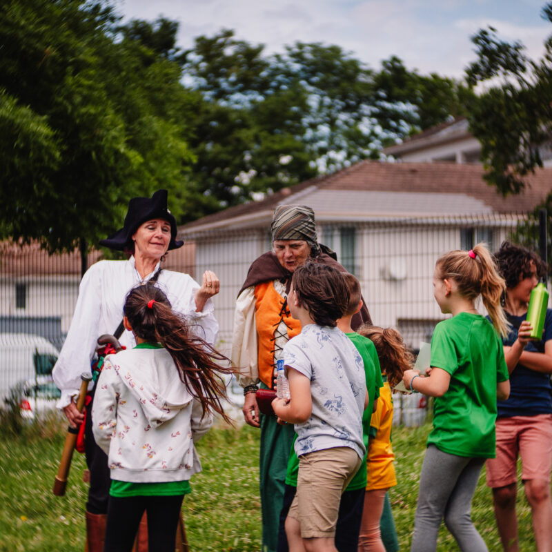 Groupe de pirates et d'enfants qui écoutent la navigatrice